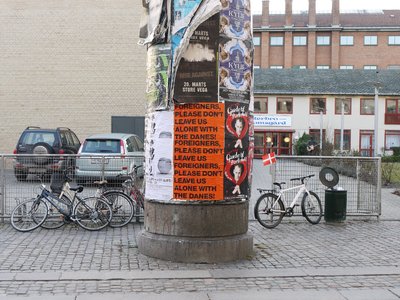 Poster of Foreigners Please Don't Leave Us Alone With The Danes!, 2002 installed in Copenhagen, 2011.